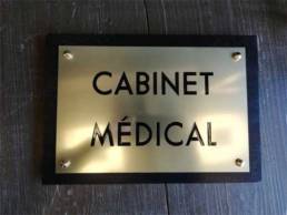 Plaque cabinet médical en laiton avec un socle en bois noir